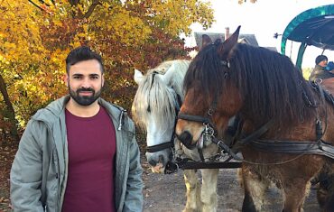 Erwachsener Mann mit Pferden im Reiterhof-Urlaub